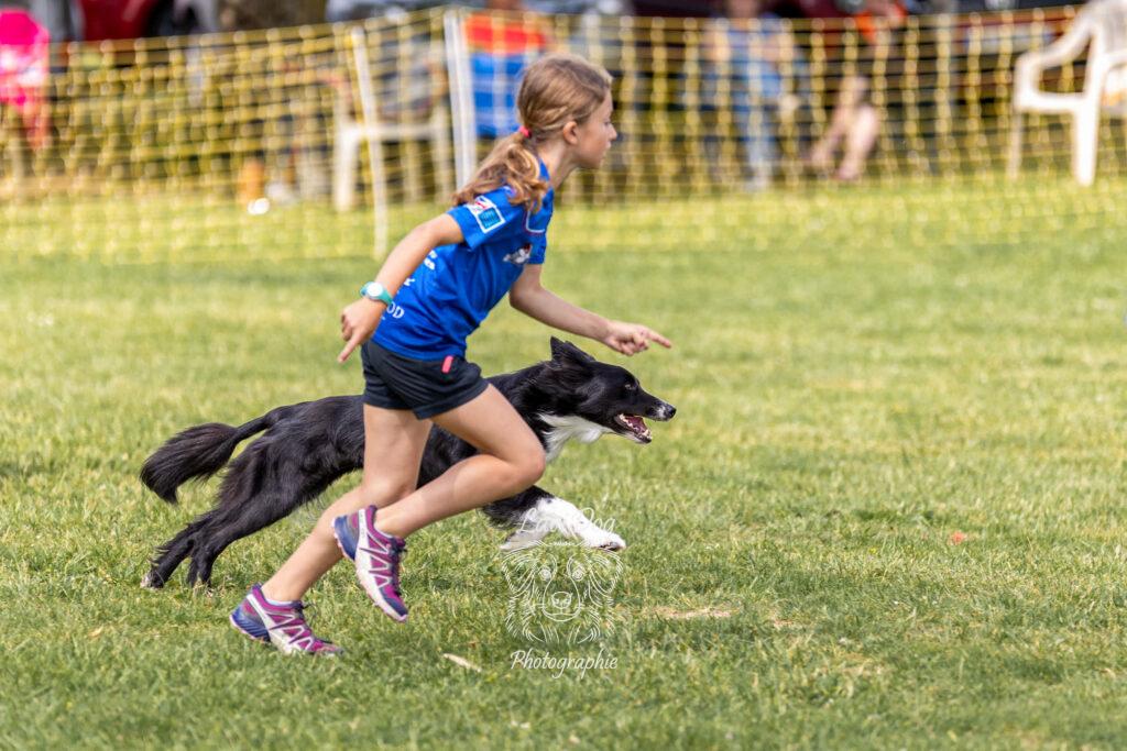 Binôme maître et chien Border Collie en course sur un parcours d'agility.